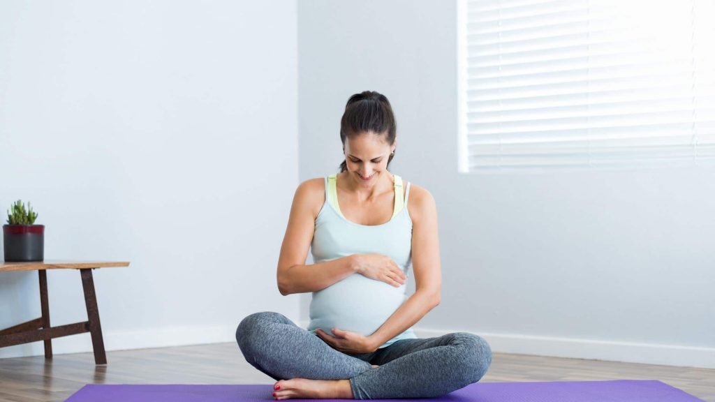 Pregnant woman in a yoga mat